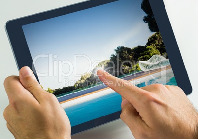 Hand touching tablet with swimming pool