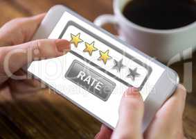 Hand holding phone with rate button and star reviews