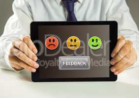 Hands holding tablet with smiley face feedback satisfaction icons