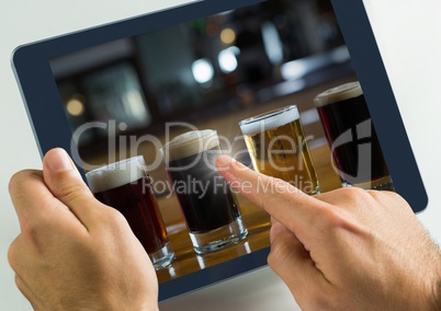 Hand touching tablet with beers selection in bar
