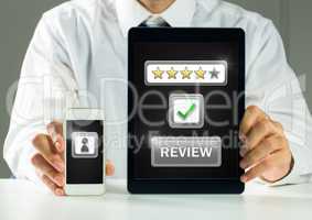 Man holding tablet and phone with review star ratings
