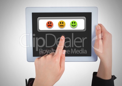 Hand holding tablet with smiley face feedback satisfaction buttons