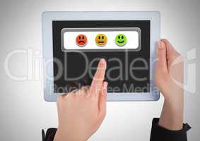 Hand holding tablet with smiley face feedback satisfaction buttons