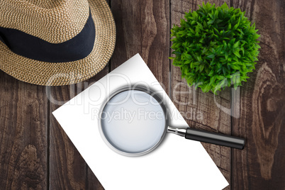 Magnifying glass on paper on side of a brown hat