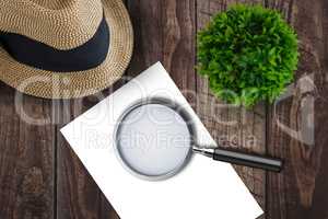 Magnifying glass on paper on side of a brown hat
