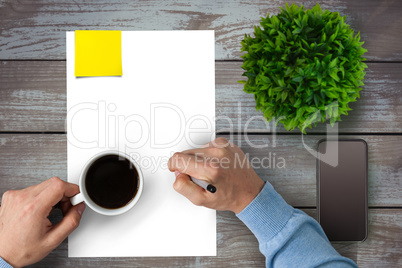Man drinking coffee on a piece of paper