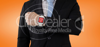 Composite image of mid section of businessman in suit wearing smartwatch