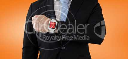 Composite image of mid section of businessman in suit wearing smartwatch