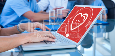 Composite image of doctor typing on keyboard with her team behind