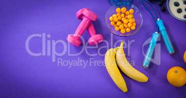 Food with exercise equipment against purple background