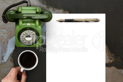 Man drinking coffee in front of paper and phone