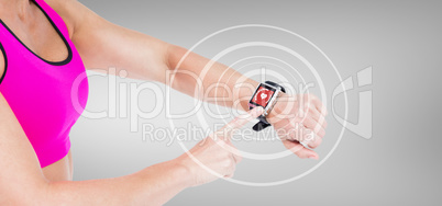 Composite image of female athlete using her smart watch