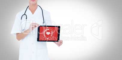 Composite image of midsection of female doctor showing digital tablet