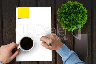 Man drinking coffee on a piece of paper