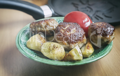 Cutlets , baked with spices potatoes and tomatoes.