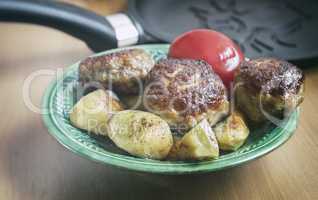 Cutlets , baked with spices potatoes and tomatoes.