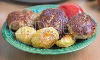 Cutlets , baked with spices potatoes and tomatoes.