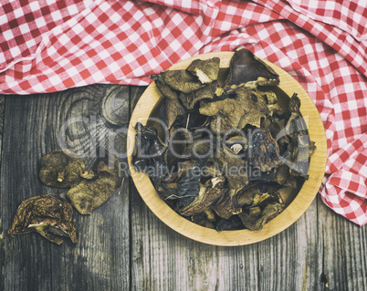 A dried forest mushroom in a wooden plate