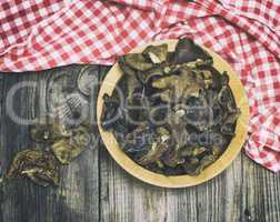 A dried forest mushroom in a wooden plate