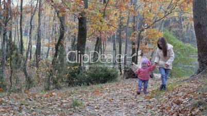 girl walks with her little sister in a beautiful park