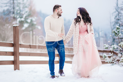 young couple on a walk in the snowy mountains