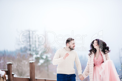 young couple on a walk in the snowy mountains