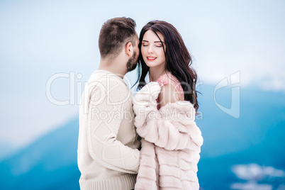 young couple on a walk in the snowy mountains