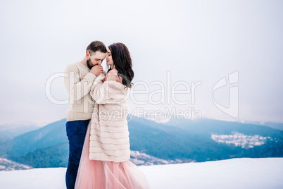 young couple on a walk in the snowy mountains