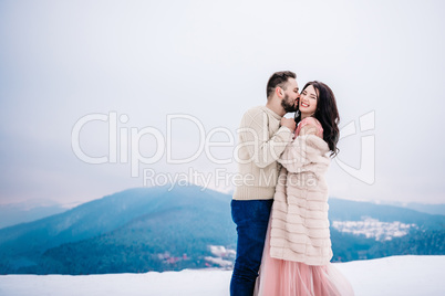 young couple on a walk in the snowy mountains