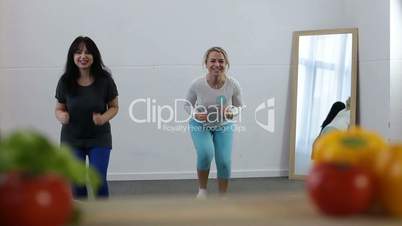 Two sporty women doing fitness exercise at home