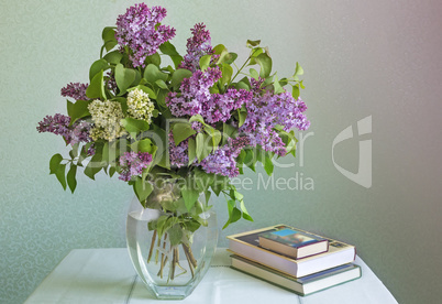 Still life: bouquet of lilacs and books.