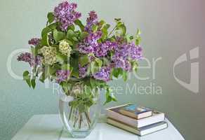 Still life: bouquet of lilacs and books.