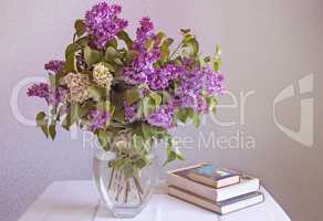 Still life: bouquet of lilacs and books.