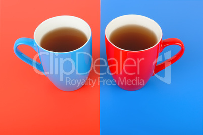 Cups with tea on a red and blue background.
