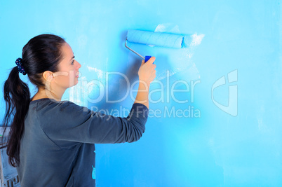 girl painter engaged in painting the walls