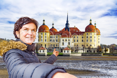 Woman points to the castle of Moritzburg