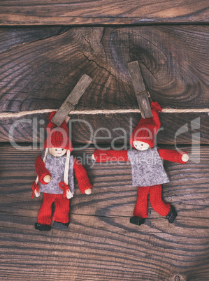 two wooden dolls hang on a rope