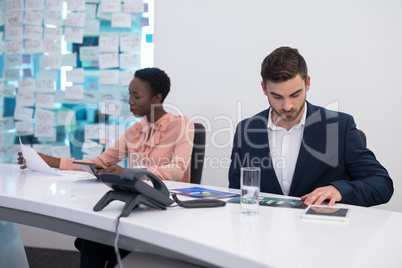 Male and female executives looking at graph