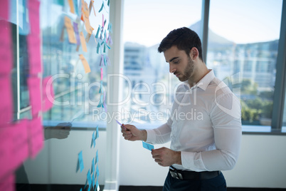 Male executive reading sticky note