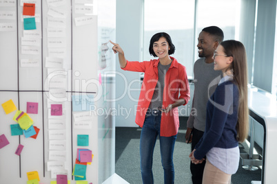 Male and female executives discussing on whiteboard