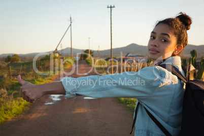 Woman hitchhiking on a sunny day