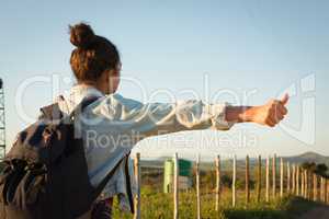 Woman hitchhiking on a sunny day