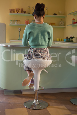 Woman sitting on chair near counter in the restaurant