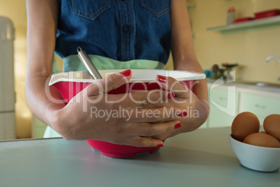Hands of woman holding bowl in the kitchen at home