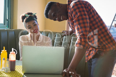 Couple using laptop in restaurant