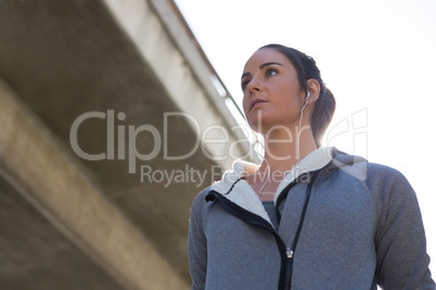 Thoughtful female jogger listening to music