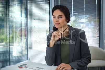 Thoughtful female executive sitting at desk