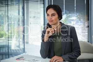Thoughtful female executive sitting at desk