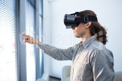 Male executive using virtual reality headset in waiting area