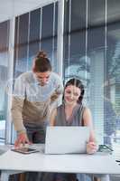 Business executives discussing over laptop at desk